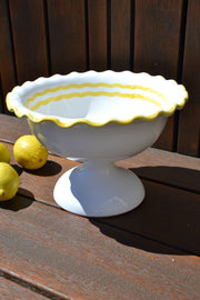 White ceramic bowl with yellow rim on a wooden surface