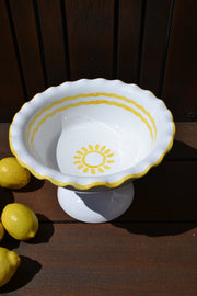 White shell-shaped ceramic bowl with yellow accents on a wooden surface